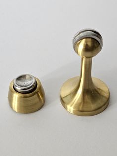 two brass knobs with one button on each side and the other is turned upside down