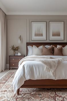 a large bed sitting in a bedroom next to two framed pictures