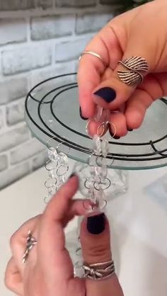 two hands are holding an object on a glass plate that has snowflakes attached to it