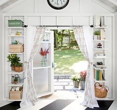 a clock is hanging on the wall above an open door to a room with bookshelves