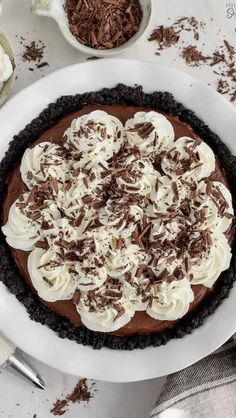 the best chocolate pie with whipped cream and chocolate shavings on top in a white bowl