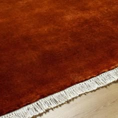 a brown rug with fringes on top of it