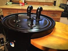 a large black machine sitting on top of a wooden table next to a kitchen counter