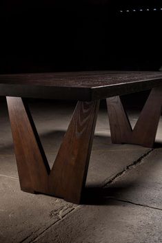 a wooden bench sitting on top of a cement floor