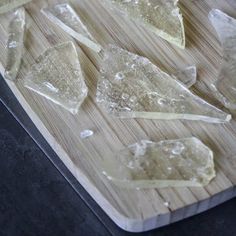 pieces of ice on a cutting board with some water droplets all over the top and bottom