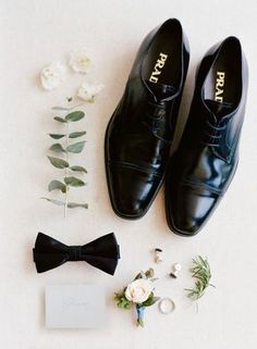 the groom's shoes and boutonnieres are laid out