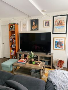 a living room filled with furniture and a flat screen tv on top of a wooden table