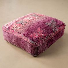 a pink rug on the floor in front of a beige wall with a white background