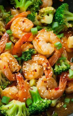 shrimp and broccoli stir fry in a wok with sesame seeds on the side