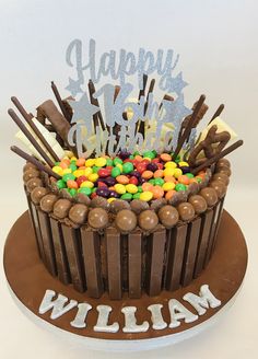 a chocolate birthday cake with candy and candies on top that says happy birthday william