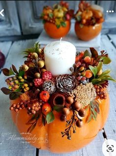 a candle is sitting on top of a pumpkin decorated with autumn leaves and other decorations