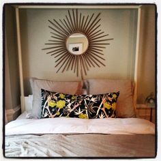 a bedroom with a sunburst above the bed and pillows on the headboard