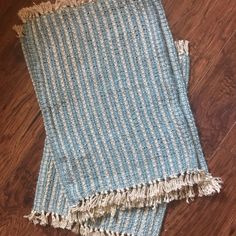 two blue and white towels laying on top of a wooden floor