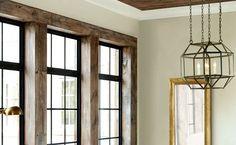 a living room filled with furniture and windows next to a wooden floor covered in wood planks