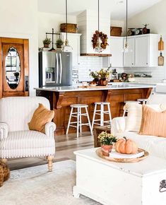 a living room filled with furniture next to a kitchen