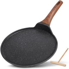 an empty cast iron skillet with wooden handle next to a spatula on a white background