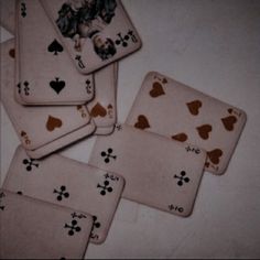 four playing cards with hearts and spades are on the table next to each other