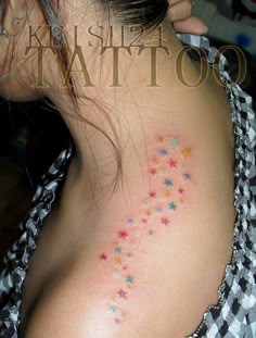 a woman with colorful stars on her back shoulder