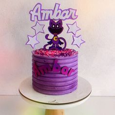 a birthday cake with purple frosting and sprinkles on top that says ambar