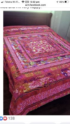 a bed with a pink quilt on top of it