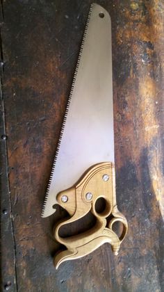 a wooden cutting board with a large knife on it's side and a pair of scissors next to it