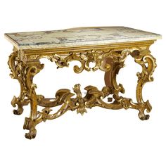 an antique console table with marble top and gold leaf decorations on the legs, against a white background