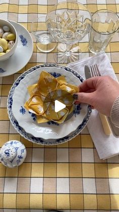 a person holding a piece of food on top of a plate next to an egg