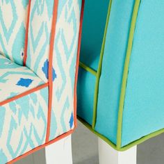 two colorful chairs sitting next to each other on top of a carpeted floor and one chair with an upholstered seat