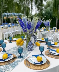 the table is set with blue and white plates, silverware, and lemons