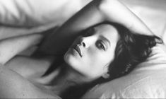 a black and white photo of a woman laying in bed