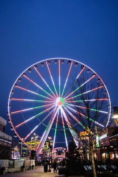 the ferris wheel is lit up at night