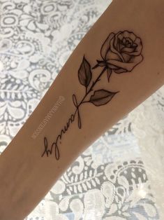 a woman's arm with a rose tattoo on it that reads, namiya