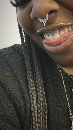 a woman with some piercings on her nose and tongue is smiling at the camera