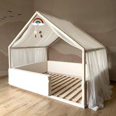 a child's bed with a canopy and curtains on the top is made to look like a house