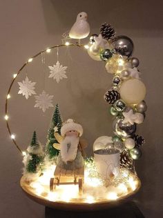 a christmas display with lights and decorations on the top, including a teddy bear sitting in a sleigh surrounded by snowflakes