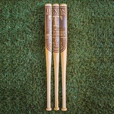 two wooden baseball bats laying on the grass