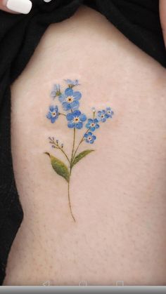 small blue flowers on the back of a woman's shoulder