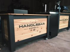 a wooden counter sitting in the middle of a room next to a coffee shop sign