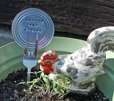 a planter with a fork and knife sticking out of it's head in the soil