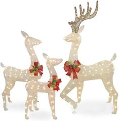 two white deer statues with red bows on their antlers