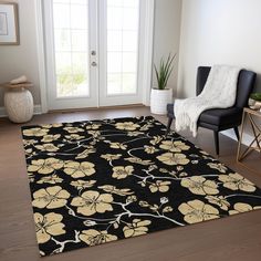 a black rug with yellow flowers on it in front of a white door and chair