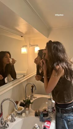 a woman brushing her teeth in front of a mirror