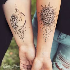 two people holding hands with tattoos on their arms and one has a sun and moon