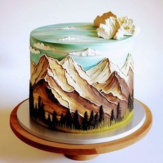 there is a cake decorated with mountains and trees