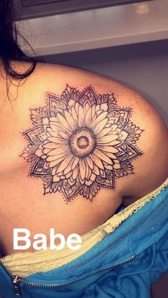 a woman with a sunflower tattoo on her shoulder and the words babe below it