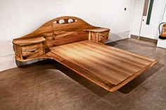 a wooden bed frame with drawers on the bottom and headboard made out of wood