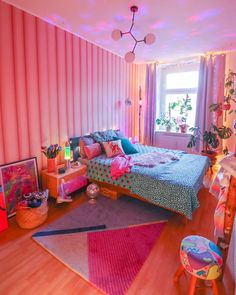 a bedroom decorated in pink, blue and green with lots of lights on the ceiling