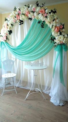 a wedding arch decorated with flowers and ribbons