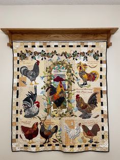 a quilt hanging on the wall with chickens and roosters