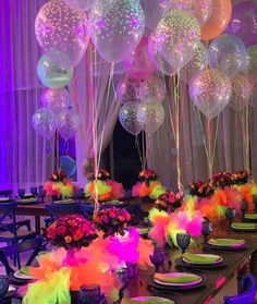 a long table with many balloons and plates on it